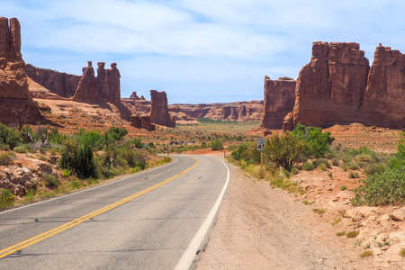 Three Gossips and Courthouse Towers rocks in the Arches National Park, Utah, on a beautiful sunny day of spring. Road winding through scenic Utah desert. Driving in the American southwest.の写真素材