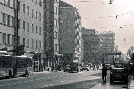 Stockholm, Sweden - 04.16.2017: Black and white street photo of a people walking down the street in a snow shower while sun is shining on a chilling day of spring in Swedish capital.のeditorial素材