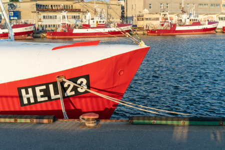 Hel, Poland - 08.01.2021: Shot of red and white fishing boat tied to pier on a beautiful sunny summer day with Baltic sea in the background.のeditorial素材