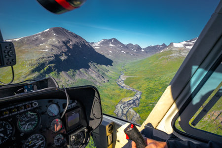 View from cockpit of small helicopter on wild river and mountains in vast Arctic landscape. Rijddanjunjesjagasj river in Sarek National Park, Sweden. Hiking in remote Swedish Lapland. Laponia summer.の写真素材