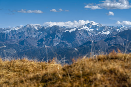 Reichenspitze and Kuchelmooskopf peaks covered in snow and ice on a beautiful sunny day of autumn in Austrian Alps. Dramatic cliffs of Alpine moutains with autumn colored meadows in front.の写真素材