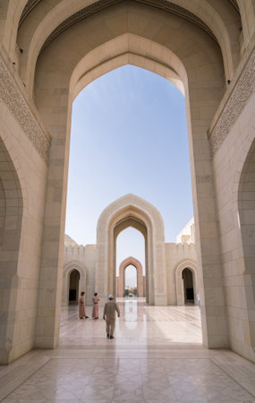 Muscat, Oman - 04.04.2018: Tourists and guards walking in the courtyard of the Sultan Qaboos Grand Mosque, Muscat, Oman. Beautiful contemporary Arabian architecture.のeditorial素材