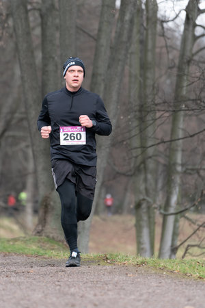 Ostrava, Czechia - 02.04.2023: Vertical shot of male runners in sportswear competing during winter amateur run race. Run competition during cold winter day. Innogy winter run.のeditorial素材