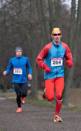Ostrava, Czechia - 02.04.2023: Vertical shot of male runners in sportswear competing during winter amateur run race. Run competition during cold winter day. Innogy winter run.のeditorial素材