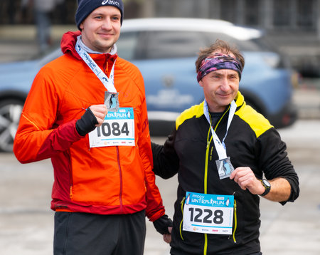 Ostrava, Czechia - 02.04.2023: Runners celebrating with their medals after amateur winter run race in the city. Innogy winter run.のeditorial素材