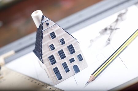 Breadboard model of a house and paper with a pencilの写真素材