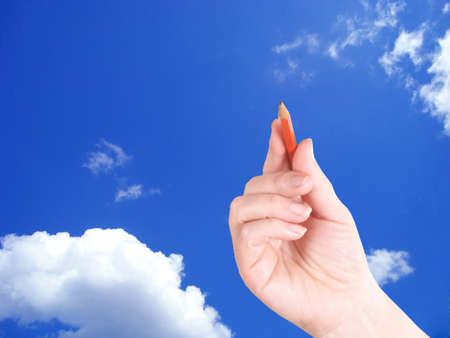 The hand writes an inscription in the skyの写真素材