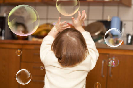 The small girl plays with soap bubbles. Childhoodの写真素材