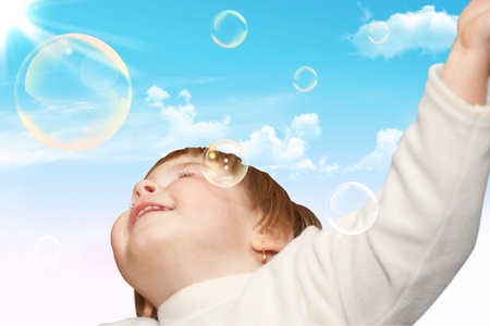 The small girl plays with soap bubbles. Natureの写真素材