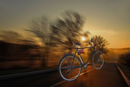 The bicycle quickly rushes on a highway. Sunsetの写真素材