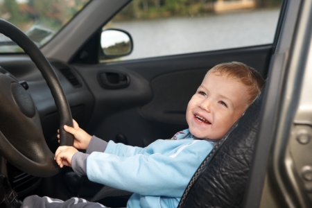Funny boy car driver with the steering wheelの写真素材