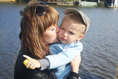 The young mother kisses the small son