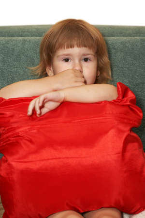 Portrait of  small girl with a red pillowの写真素材