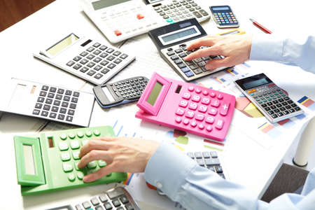 Mature businesswoman and calculators. Calculation at office