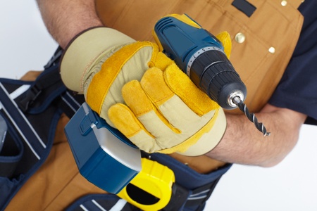 Contractor working with electric drill. The carpenter