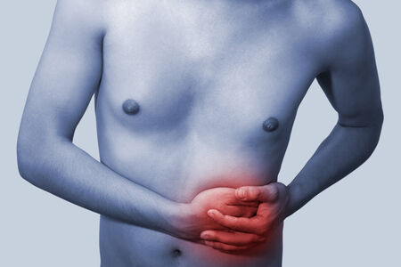 The young man keeps for stomach. On a blue background