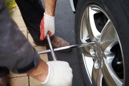 Car mechanic changing tire in professional car repair serviceの写真素材