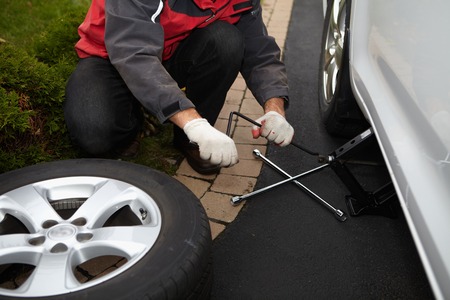 Car mechanic changing tire in professional car repair serviceの写真素材