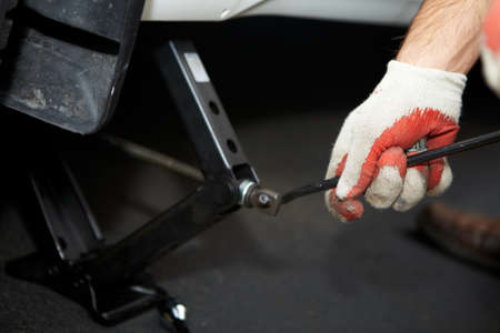 Car mechanic changing tire in professional car repair serviceの写真素材
