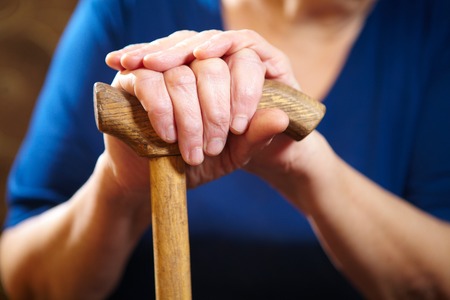 Old woman hands with cane. Senior people health care.の写真素材