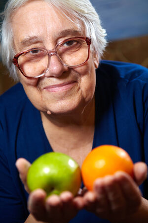 Elderly woman with fruits. Healthy diet and nutrition.の写真素材