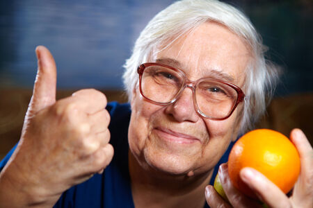 Elderly woman with fruits. Healthy diet and nutrition.の写真素材