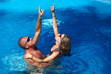Loving happy couple in pool. Summer vacation.