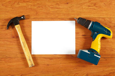 Construction tools and sheet of paper lying on a wooden floor