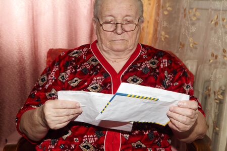 Elderly woman and open letter. Senior people and correspondenceの写真素材
