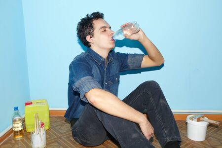 Rest. Mature contractor plasterer working indoors in blue roomの写真素材