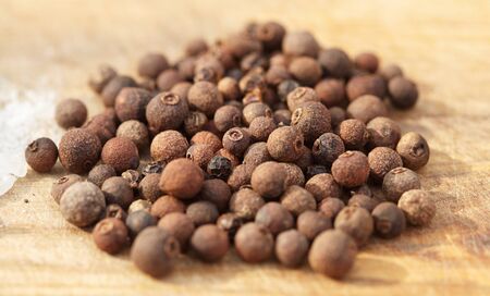 Spices. Black pepper for cooking on wooden background