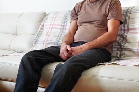 Unhappy man suffering from backache at home