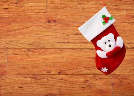 Red christmas sock hanging on brown wooden wallの写真素材