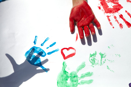 Little children draws paints on a green lawnの写真素材