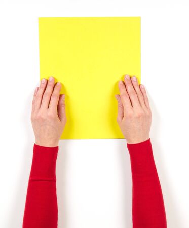 Hands and yellow paper on the table on white backgroundの写真素材