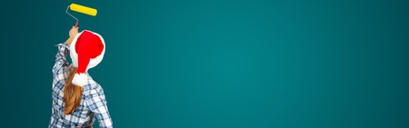 Woman with a roller. Christmas. On green backgroundの写真素材