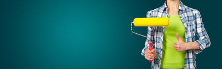 Woman with a roller. On green backgroundの写真素材