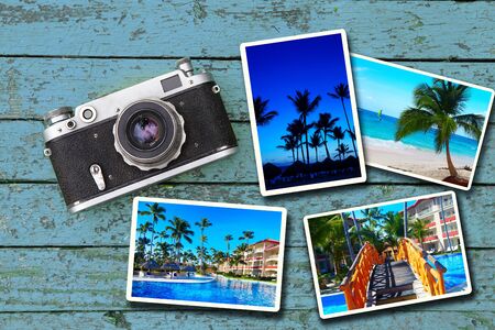 Old film camera and photographs lie on a blue wooden tableの写真素材
