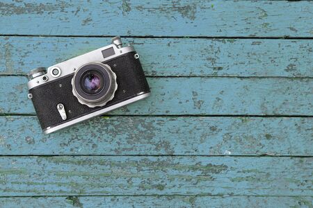 Old film camera lies on a blue wooden tableの写真素材