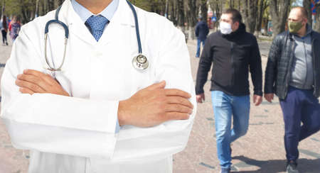 Doctor and people in medical masks on a city street during an epidemic. Znamenka city, Ukraine, 12th of April 2020のeditorial素材