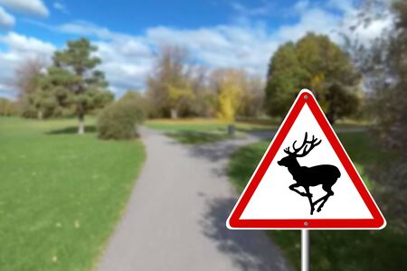 The road sign warns about wild animals. The deerの写真素材