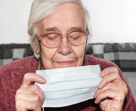 Elderly woman in a medical mask.