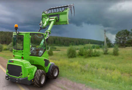 Green tractor on the field. Harvesting and hayの写真素材