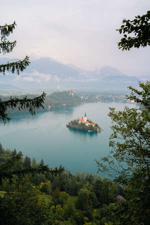Church on island on lake Bled in cloudy weatherの写真素材