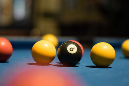 Black pool ball on a table with other ballsの写真素材