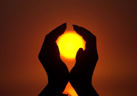 Sun in beautiful female hands during sunriseの写真素材