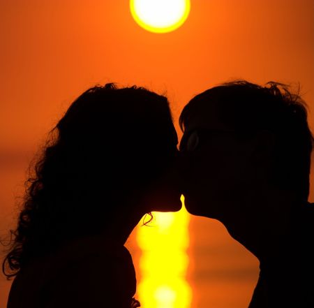 Young couple is kissing on the beachの写真素材