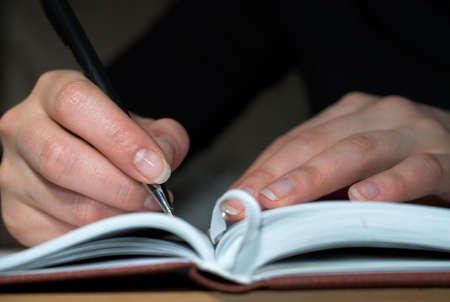 Young girl is making notes in her diary.の写真素材