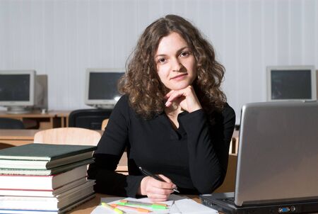 Female student is studying in office. Computers, books, laptop etc.の写真素材