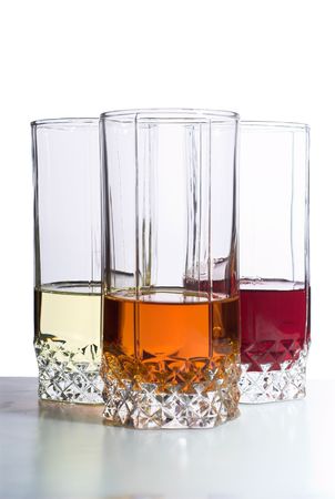 Three glasses with drinks on table. Isolated on whiteの写真素材